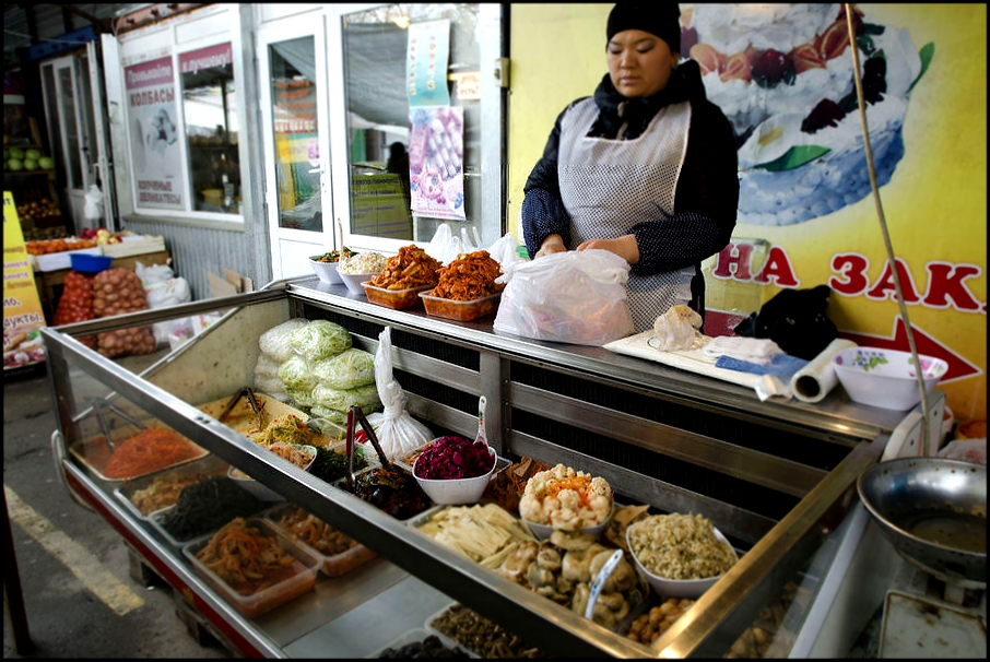 Женщина продает соленья у входа в один из алматинских супермаркетов в Казахстане. Женщины, по большей части выступающие объектами домашнего насилия,